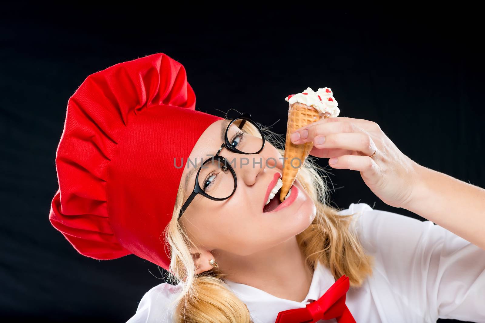 Close-up portrait of a beautiful chef with ice cream on a black background