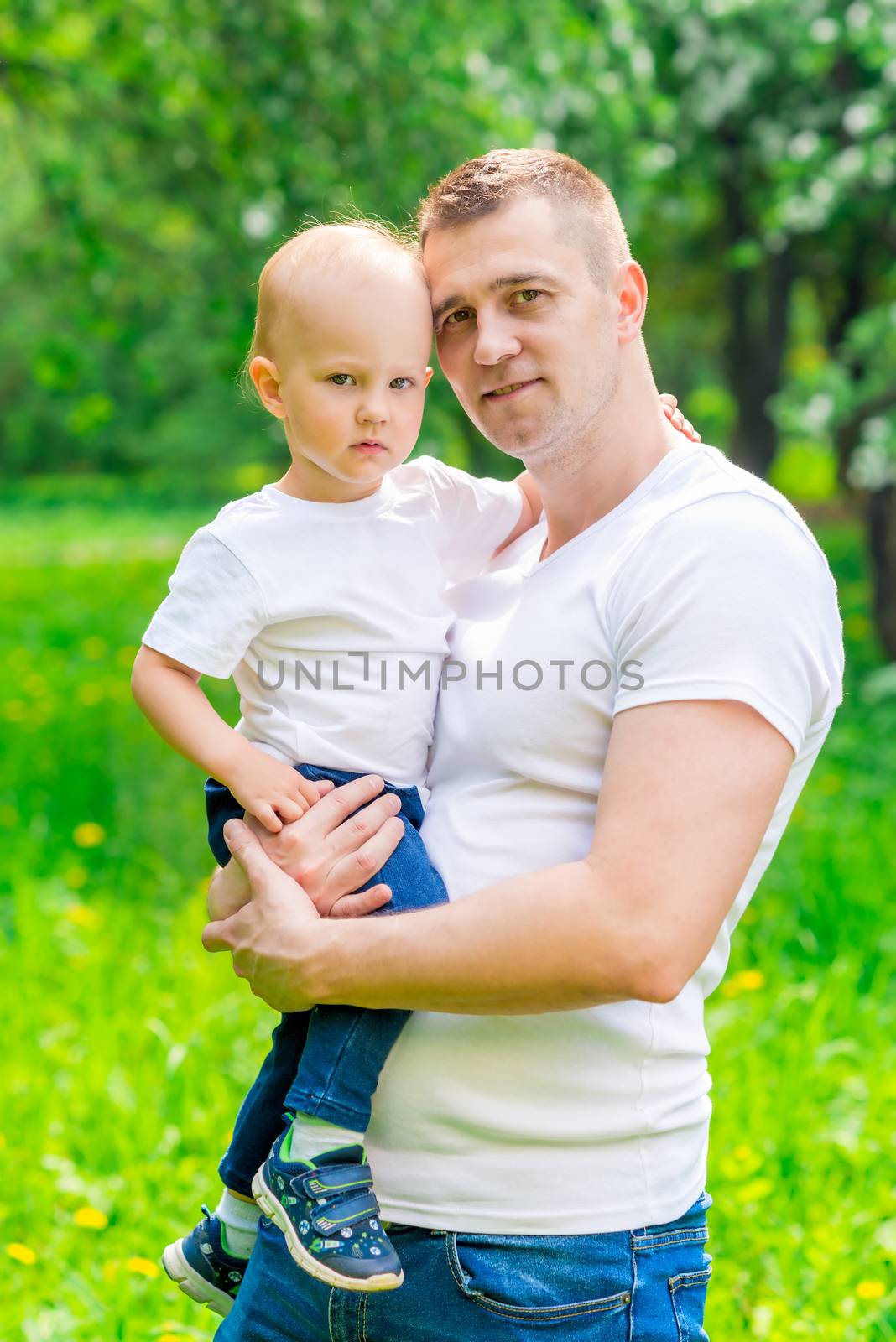 Father and son in a summer park on a walk
