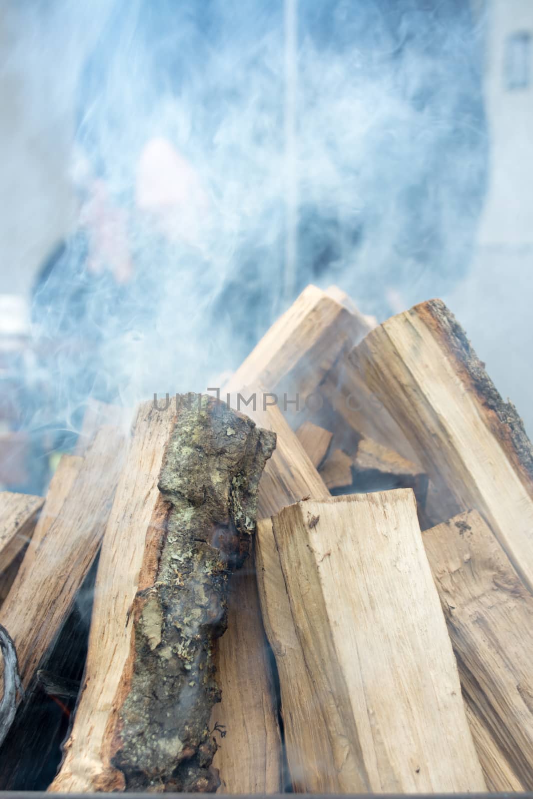 Closeup of logs smoking and burrning in preparation for nice barbecue