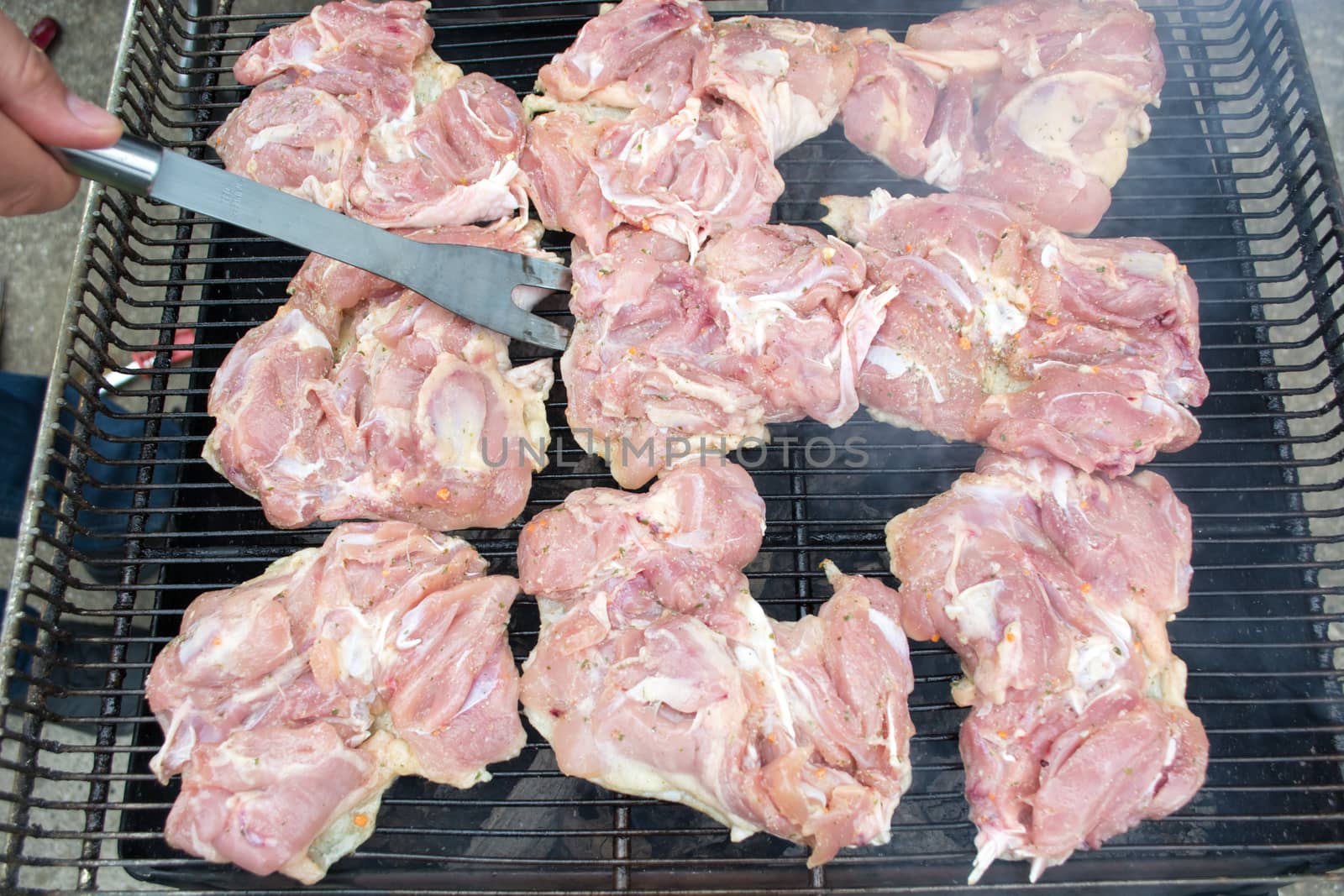 Raw pork chops on grill. Smoke rising from heated grill