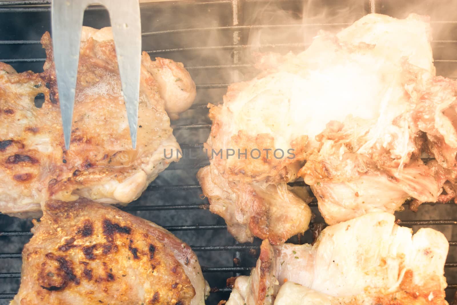 Closeup of grilled pork chops. Meat is still smoking on grill