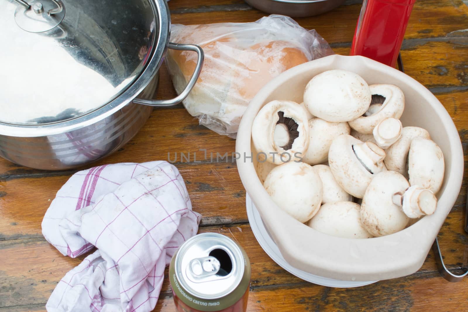 Table with bowl full of mushrooms ready to be grilled. Disorder on the table