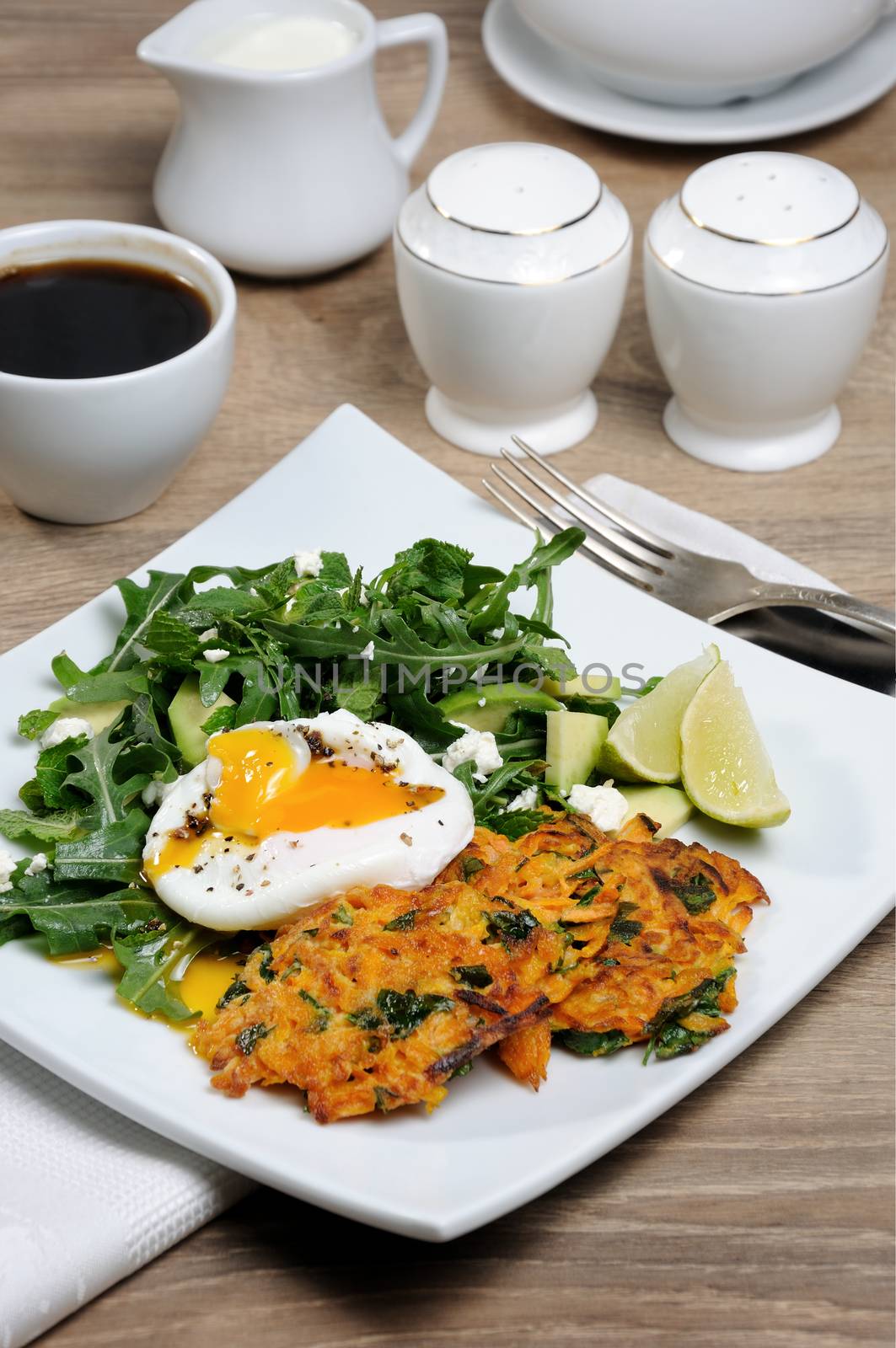 Brunch Idea. Egg poached with pumpkin spinach pancakes and garnish from arugula, avocado, mint leaves, and ricotta