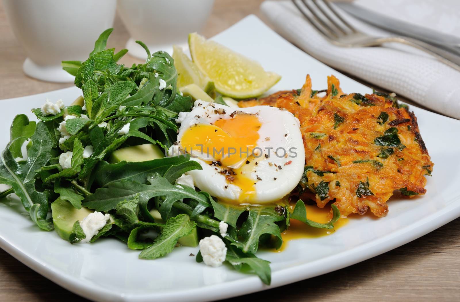Brunch Idea. Egg poached with pumpkin spinach pancakes and garnish from arugula, avocado, mint leaves, and ricotta