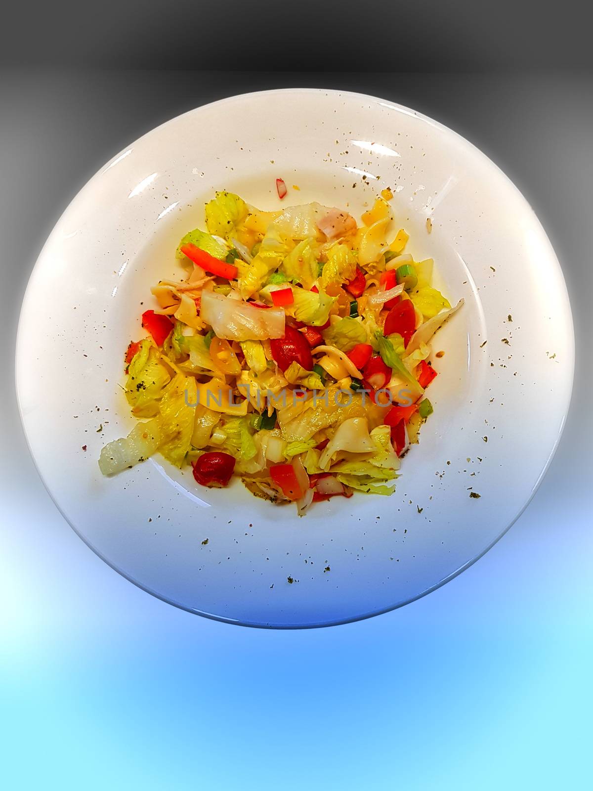 Mixed salad on a white dish in front of gradient background