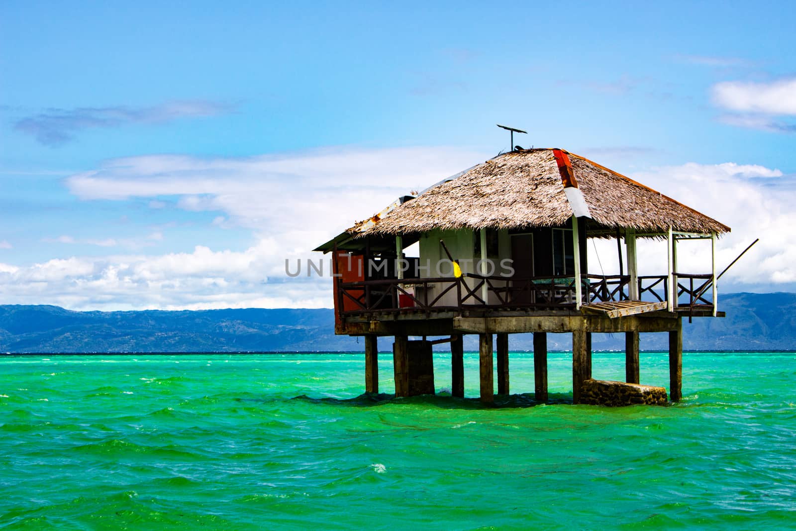 On the spit are houses on stilts. Water during the surf rises, cutting off the scythe from the land.