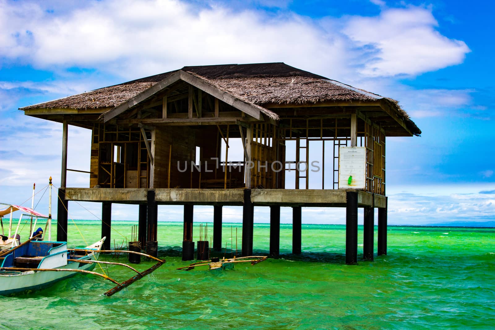 On the spit are houses on stilts. Water during the surf rises, cutting off the scythe from the land.