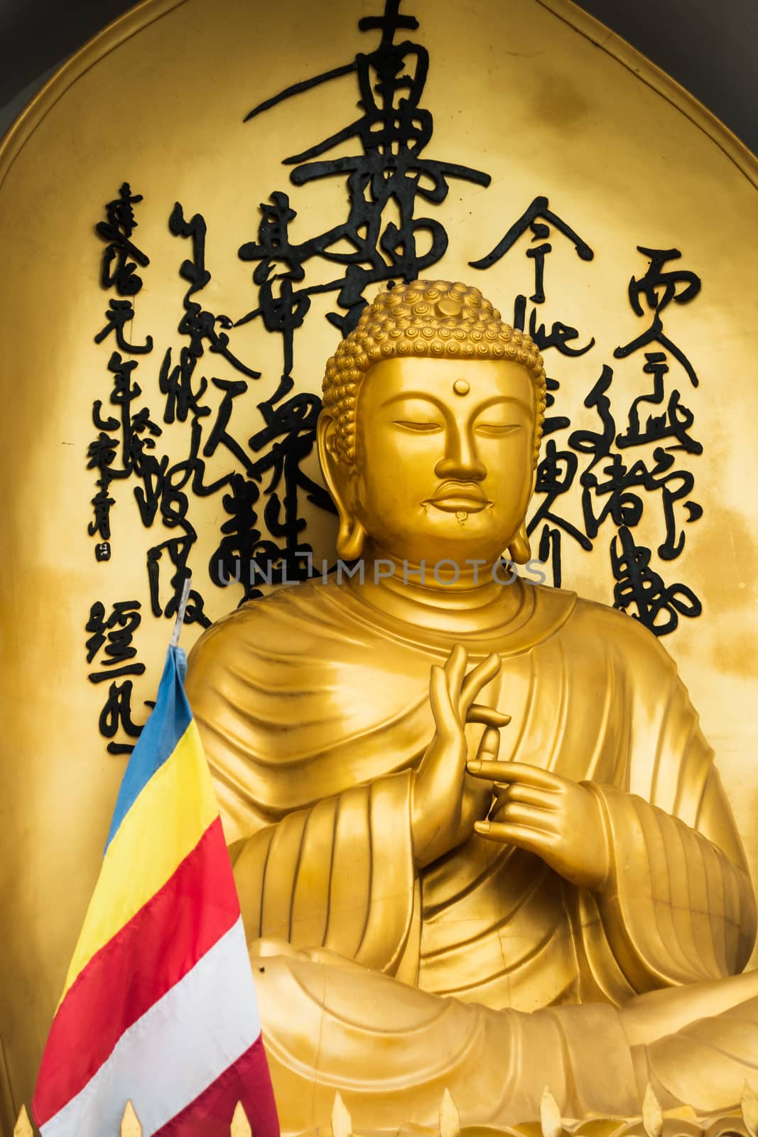 Golden Buddha statue and buddhist flag at the World Peace Pagoda in Pokhara, Nepal