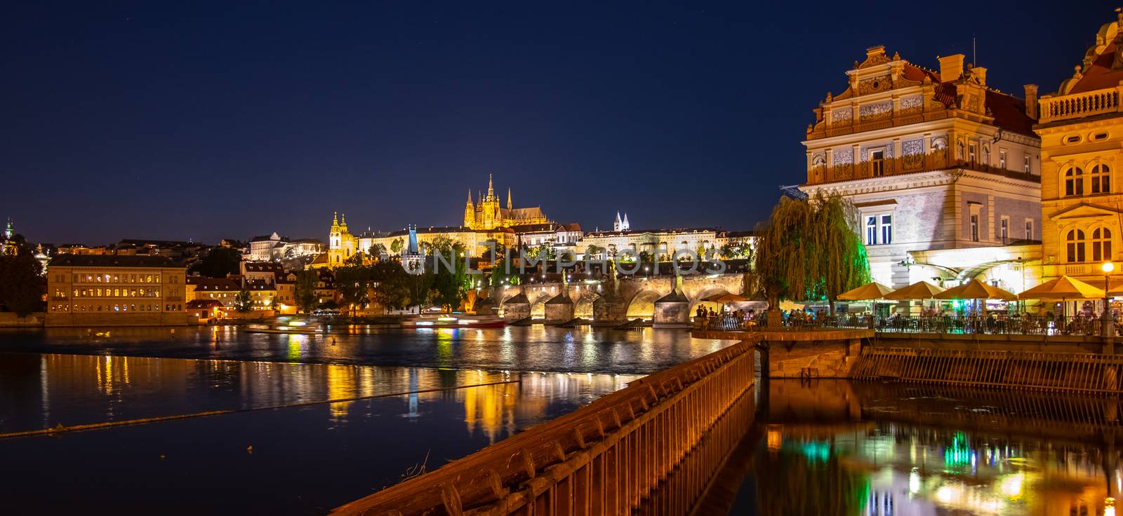 Prague by night. Prague Castle and Charles Bridge reflected in Vltava River. View from Smetana Embankment. Praha, Czech Republic by pyty