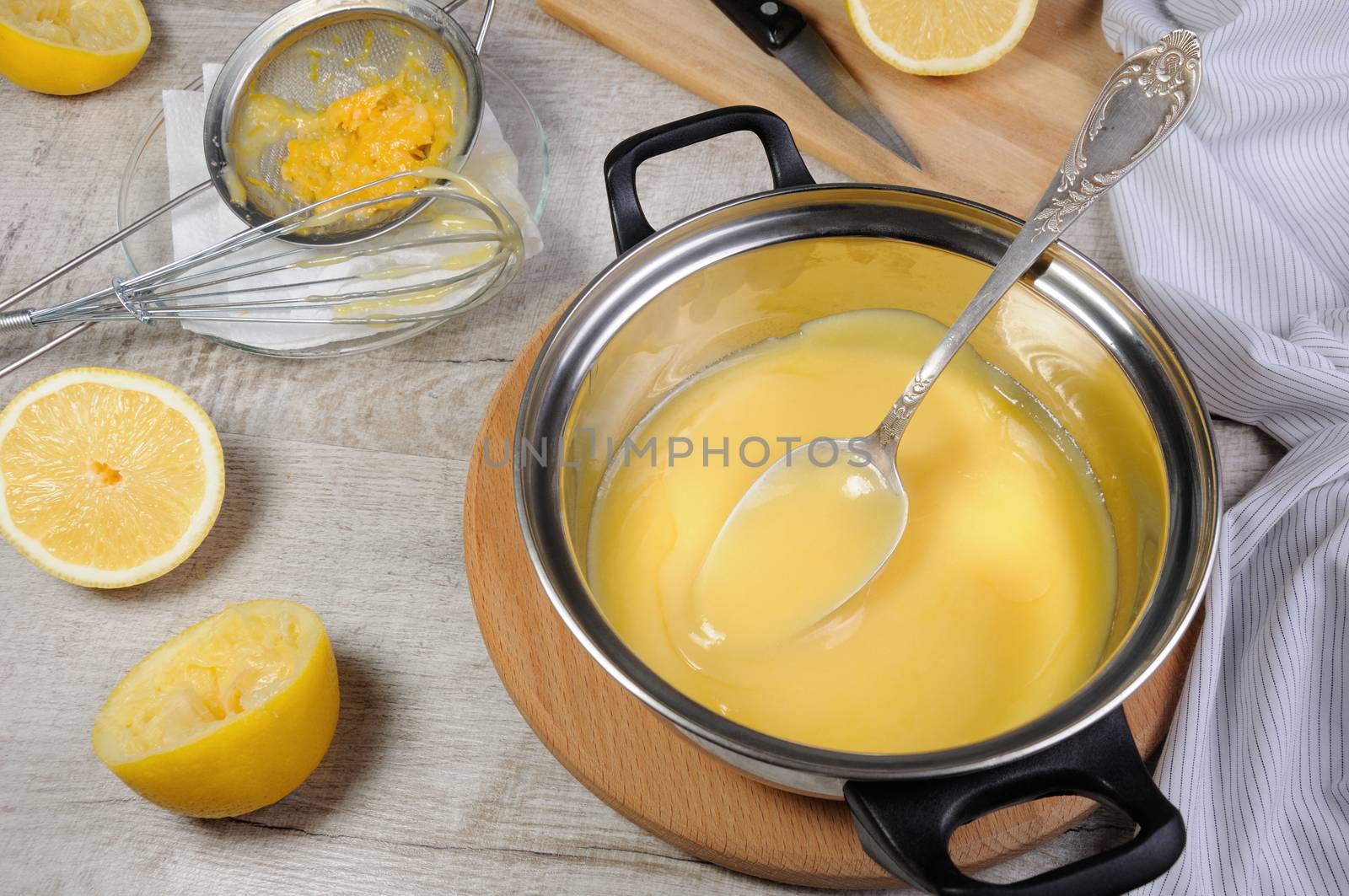 Freshly prepared lemon kurd - custard on fruit juice, in a saucepan stir with a spoon