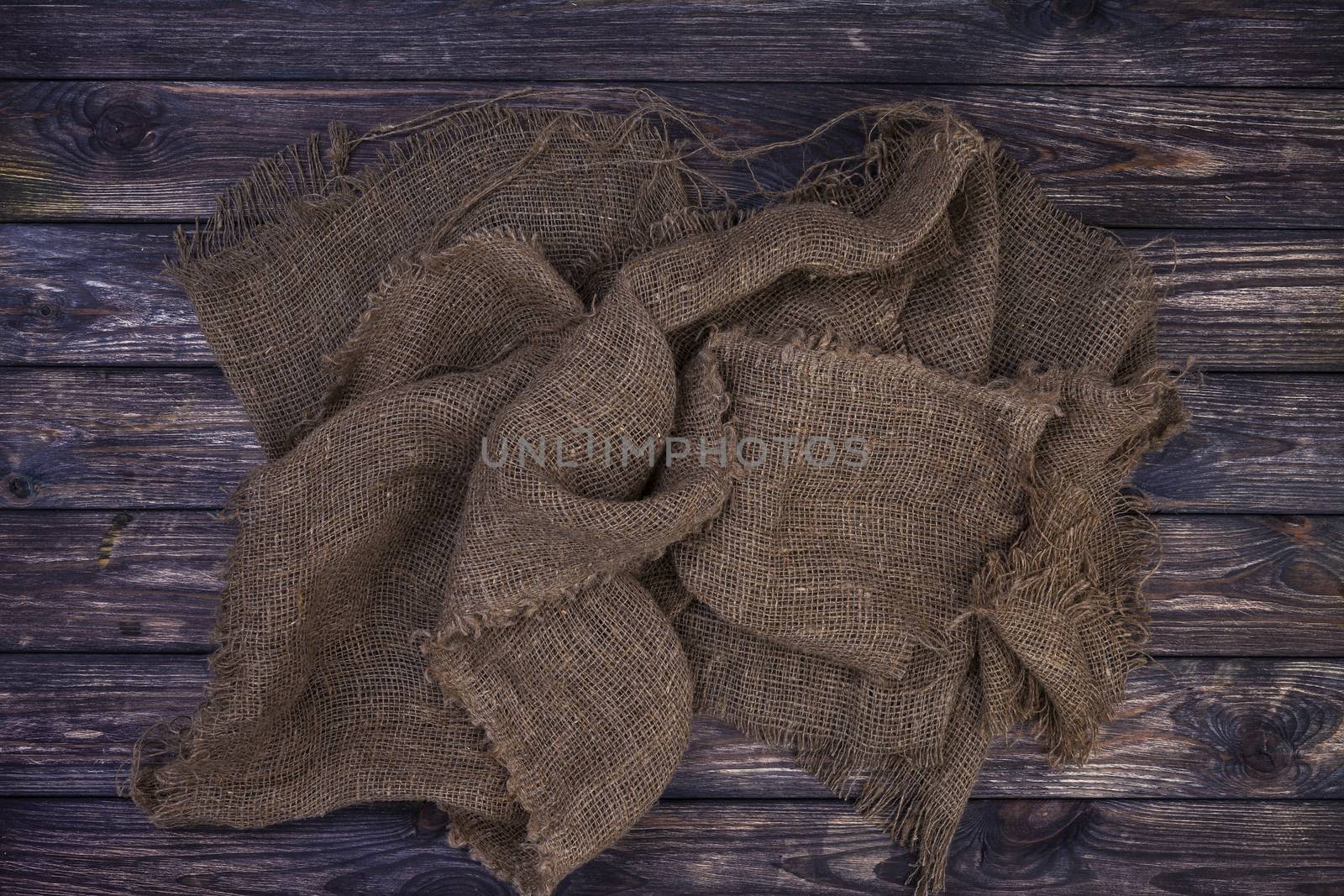 Burlap on black wooden background, top view by xamtiw