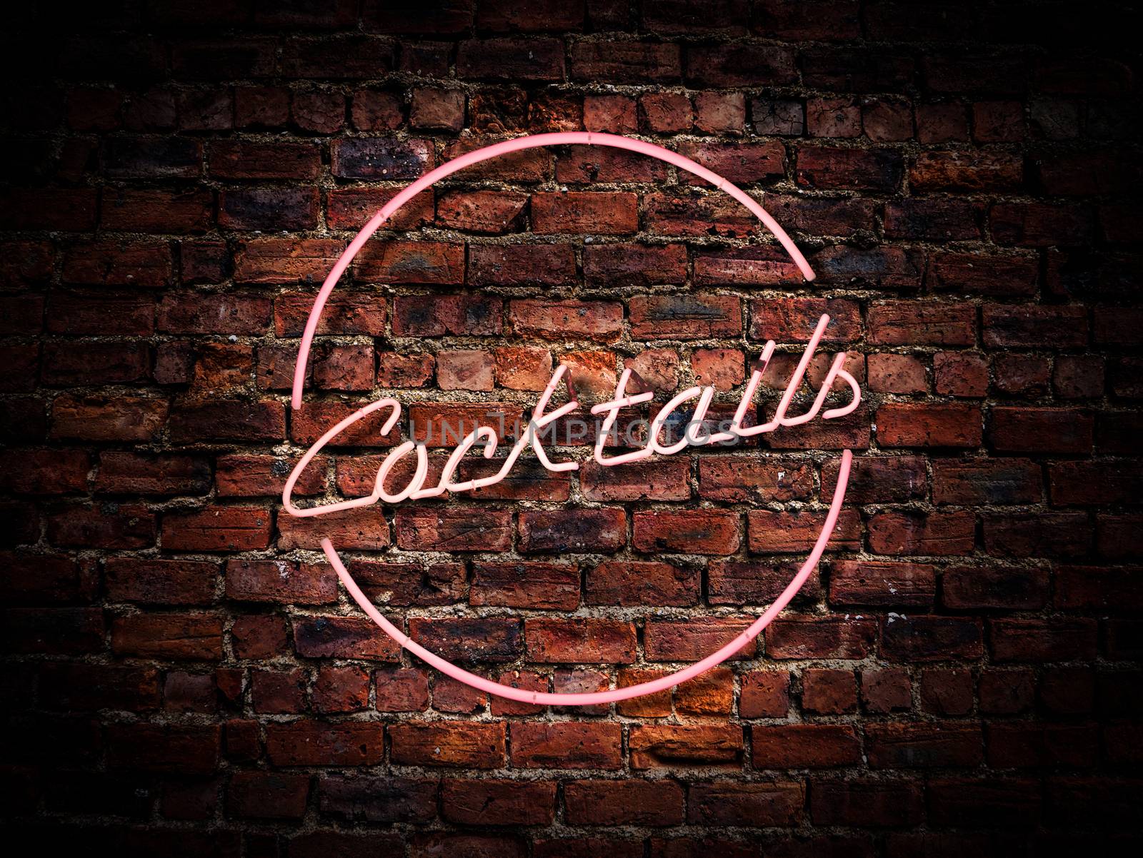 A Pink Neon Cocktails Sign Against A Red Brick Wall Outside A Bar Or Pub