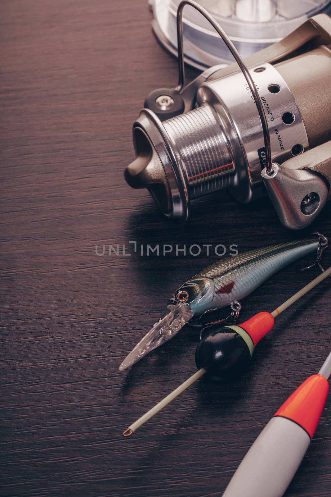 Coil and floats for a fishing rod on a wooden background