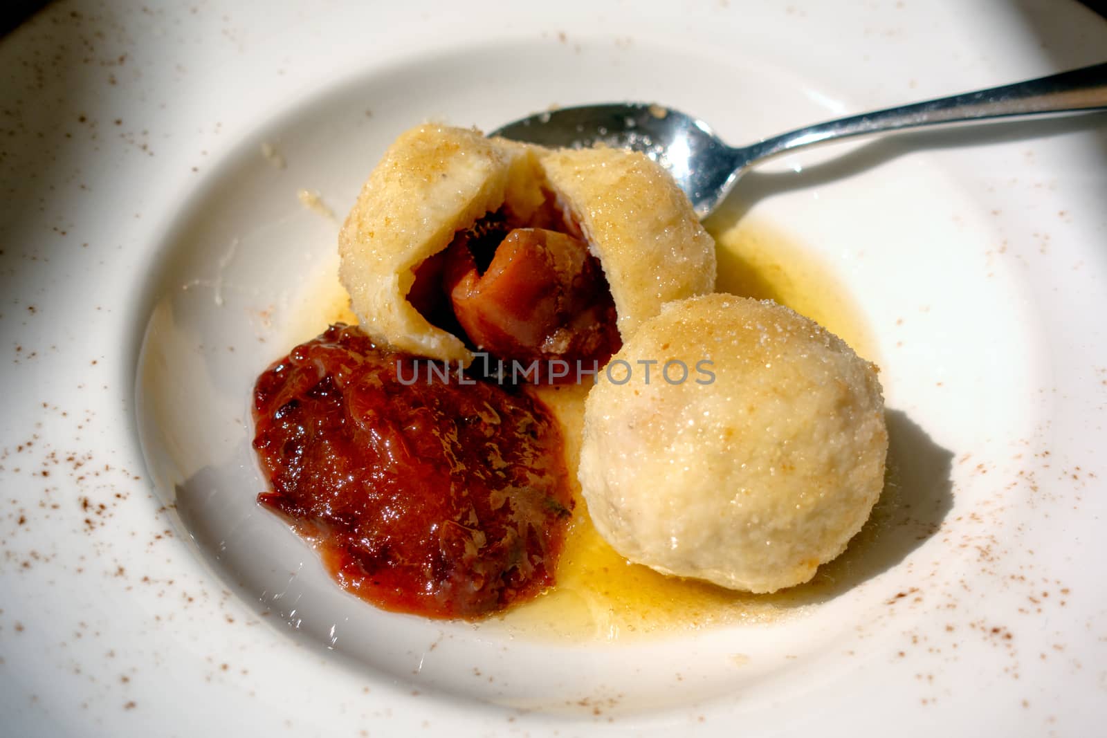 Sweet plum dumplings, one cut in half with plum jam, close up shot