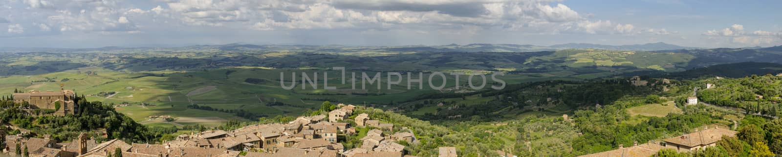 Rooftops of Montalcino and scenic view of typical Tuscany landscape in Val D'Orcia: hills, meadows and green fields. Tuscany, Italy, Europe