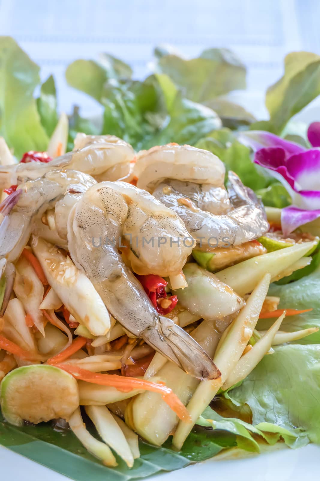 Traditional thai cuisine spicy green papaya salad with shrimp