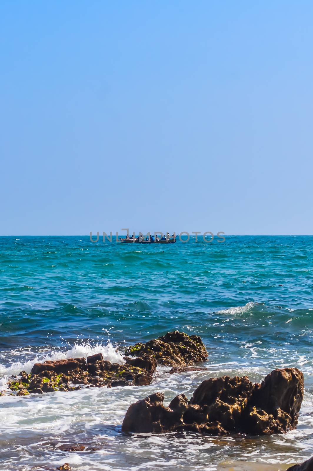 Photograph of Rowing Boat in Sea taken from a distance on a sunny day by sudiptabhowmick