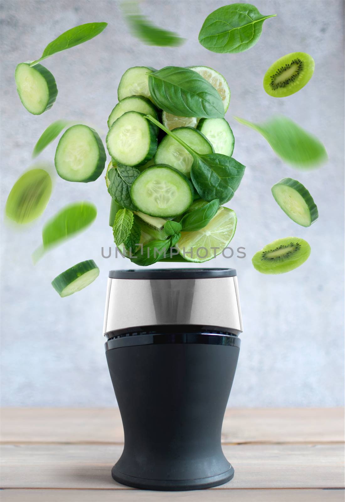 Fresh green fruits and vegetables spinning around a blender cooking concept