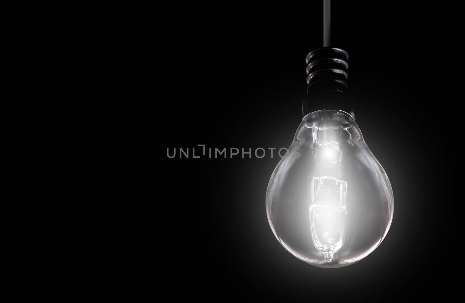 Brightly lit bulb on background with space 