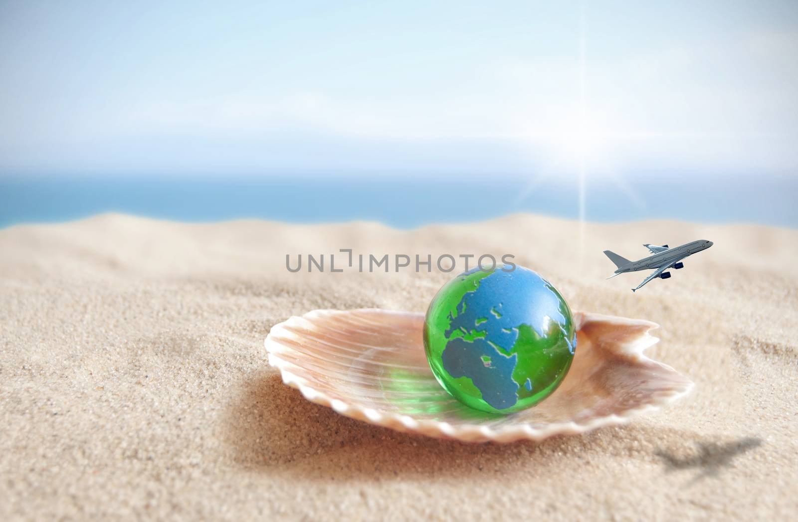Open shell with miniature world globe and airplane flying past 