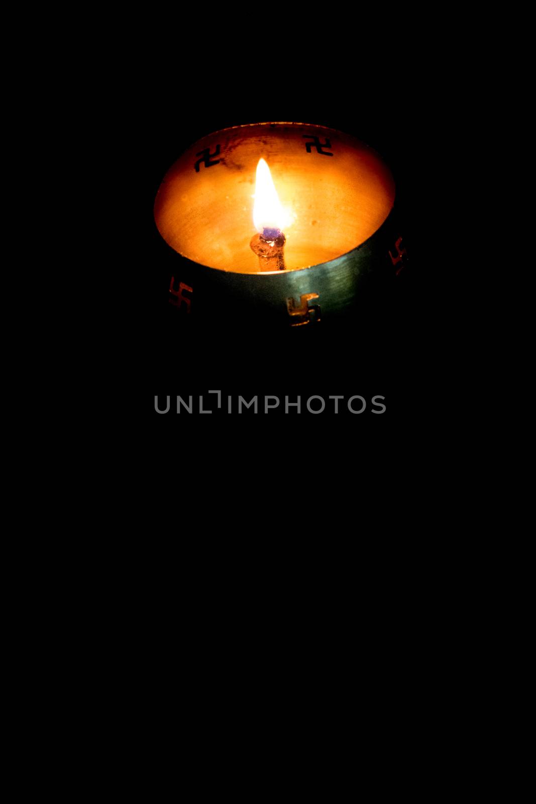 Flame of oil lamp on dark background by sudiptabhowmick