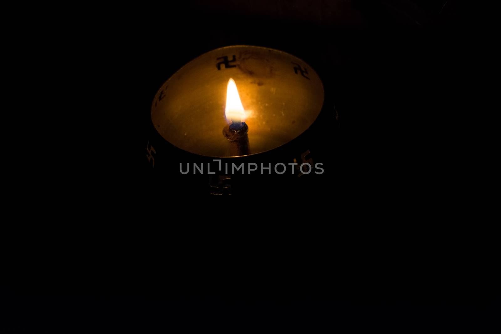 Flame of oil lamp on dark background, a burning oil lamp in darkness, with copy space. concept of removing darkness with a flame, are common in india and nepal for festival usage.