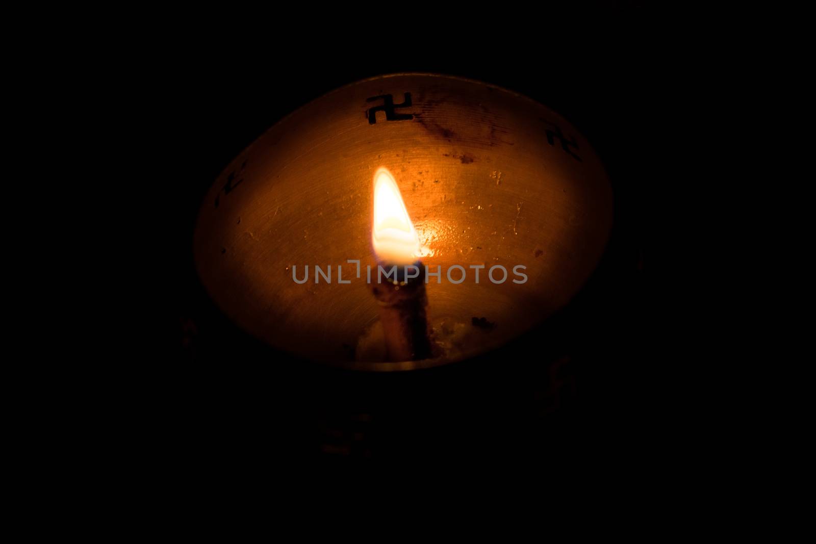 Flame of oil lamp on dark background, a burning oil lamp in darkness, with copy space. concept of removing darkness with a flame, are common in india and nepal for festival usage.