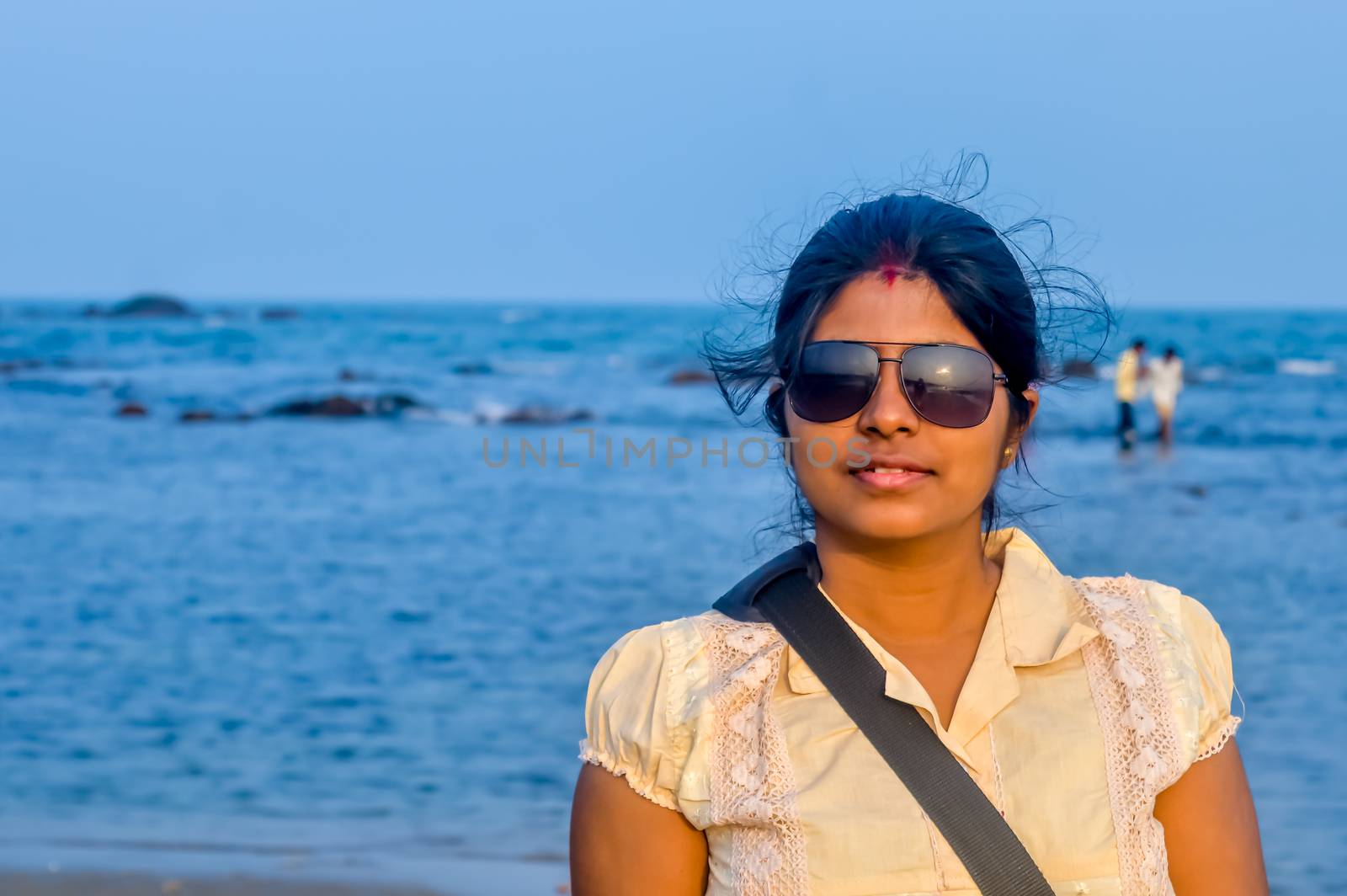 Beauty portrait of female face with natural skin. Young beautiful woman poses on the beach background.