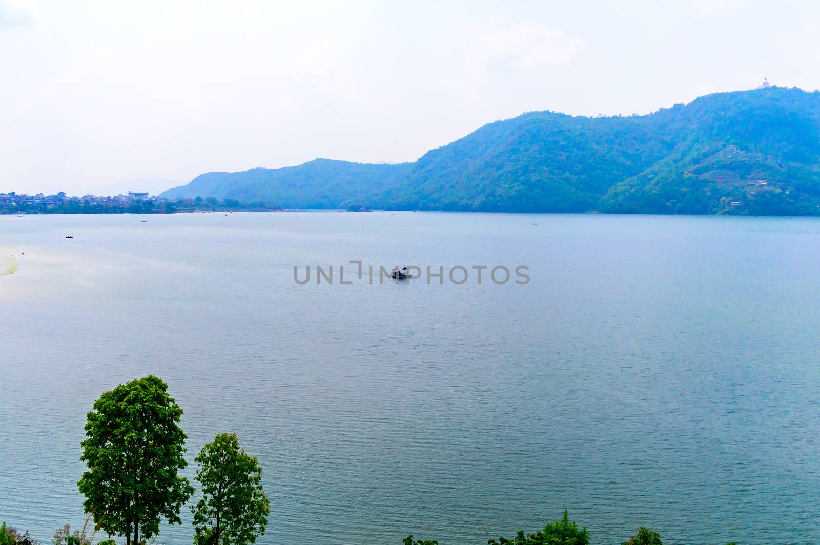 Photograph of autumn colourful lake mountain with clear sky. Wide angle landscape of Pokhara Lake at Kathmandu Nepal. Vintage film look. Vacation Freedom, Simplicity Concept.