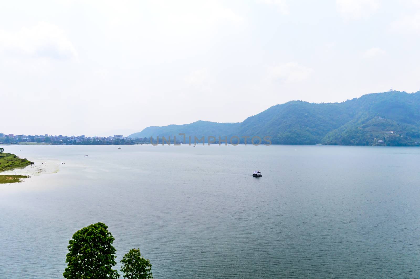 Photograph of autumn colourful lake mountain with clear sky. Wide angle landscape of Pokhara Lake at Kathmandu Nepal. Vintage film look. Vacation Freedom, Simplicity Concept. by sudiptabhowmick