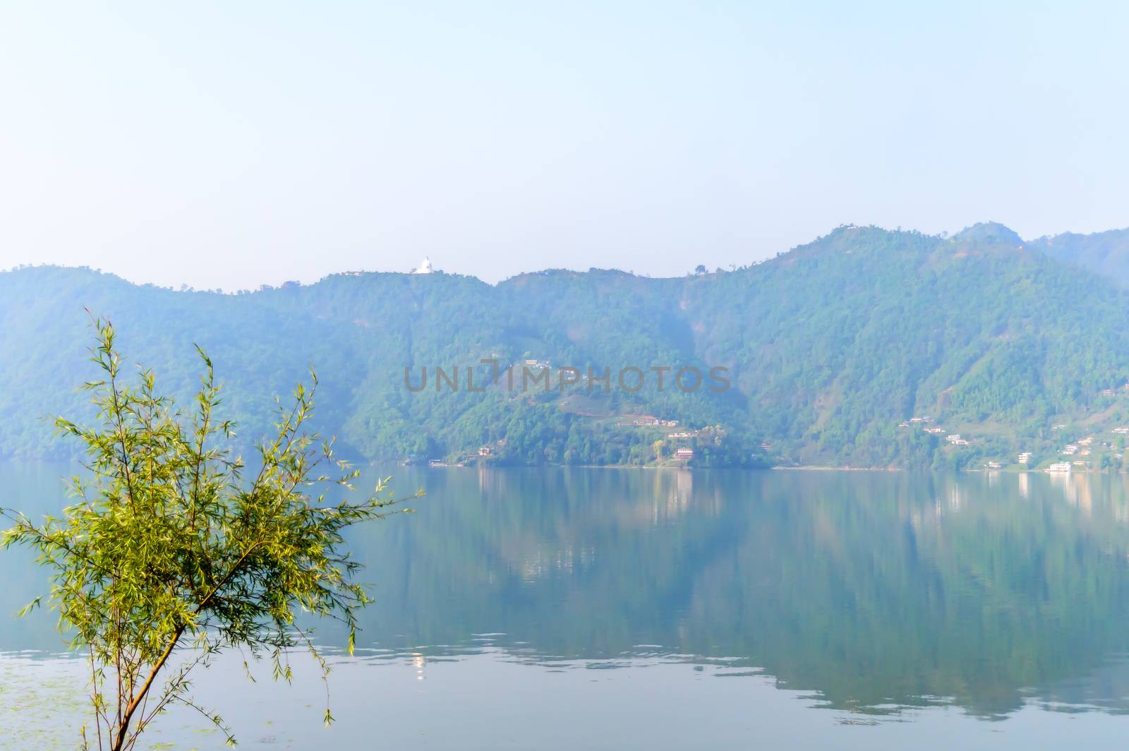 Photograph of autumn colourful lake mountain with clear sky. Wide angle landscape of Pokhara Lake at Kathmandu Nepal. Vintage film look. Vacation Freedom, Simplicity Concept. by sudiptabhowmick