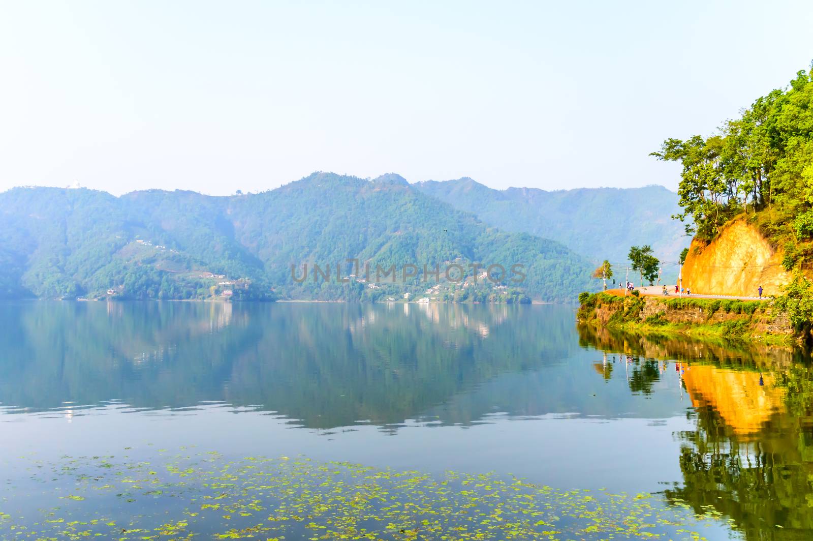 Photograph of autumn colourful lake, mountain, clear sky with reflexation in water. Wide angle landscape of Pokhara Lake at Kathmandu Nepal. Vintage film look. Vacation Freedom, Simplicity Concept. by sudiptabhowmick