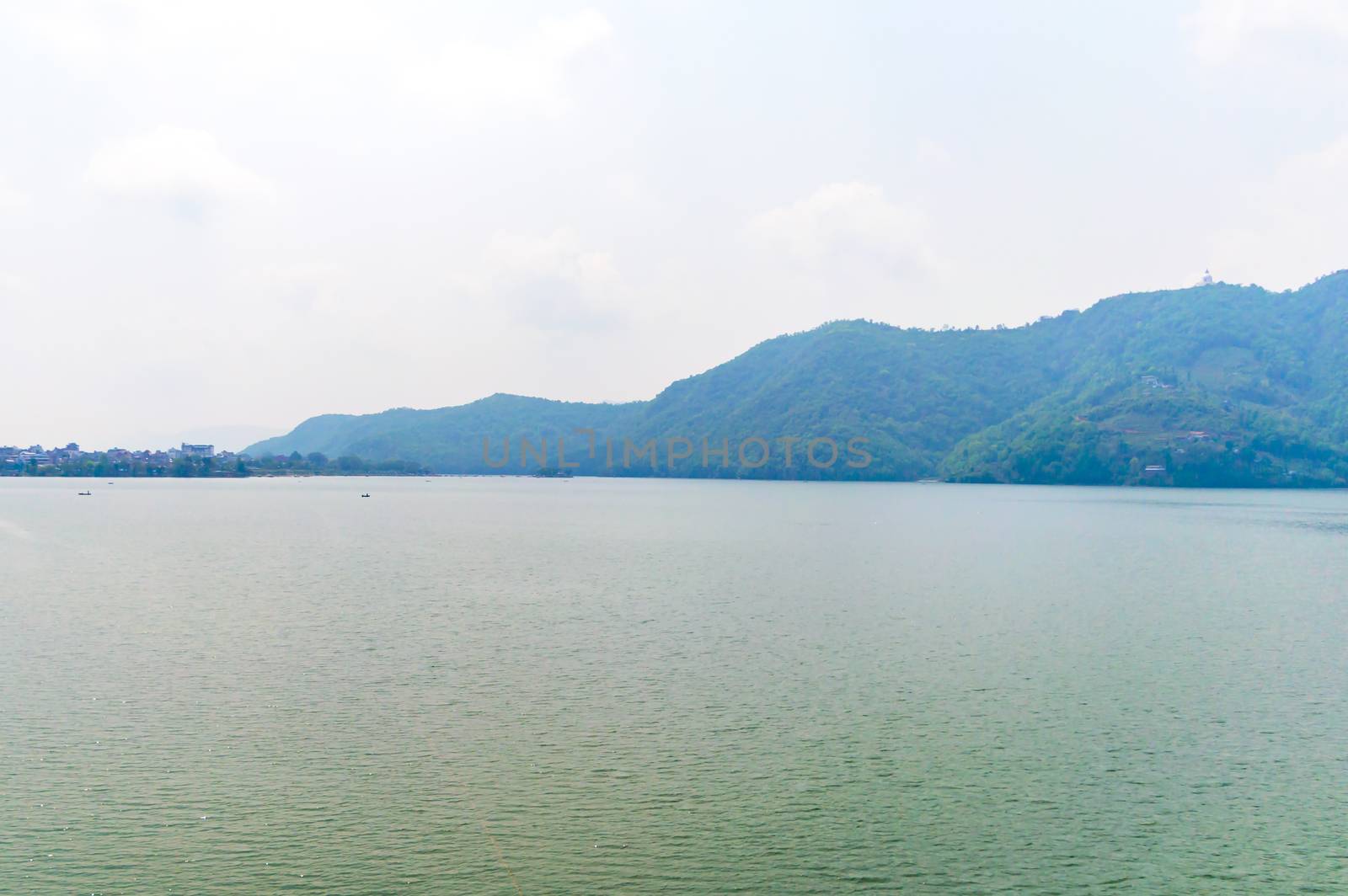 Photograph of sky, lake, mountain and reflexion Near Pokhara Lake at Kathmandu Nepal. Snap in portrait, landscape, wide screen. Vintage film look. Nature Freedom, Travel, Energy, Environment Concept.