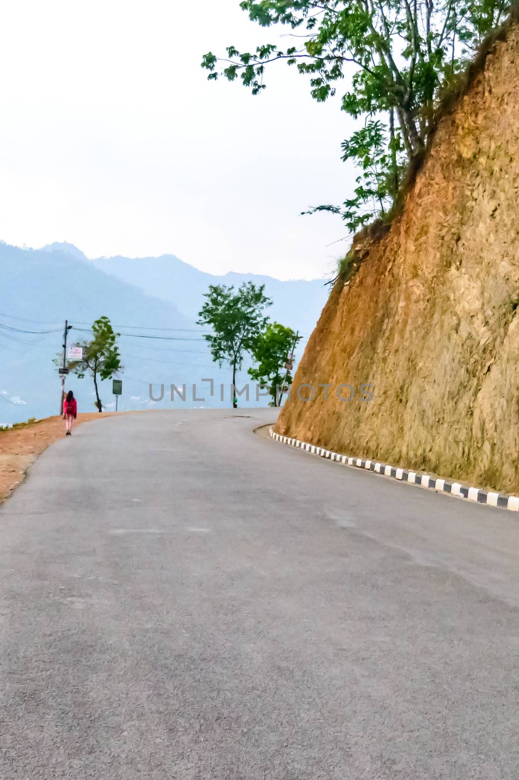 Photograph of empty road with hill in surrounding near Pokhara Lake at Kathmandu Nepal. Snap in portrait, landscape, wide screen style. Vintage film look. Vacation Freedom, Simplicity Concept. by sudiptabhowmick