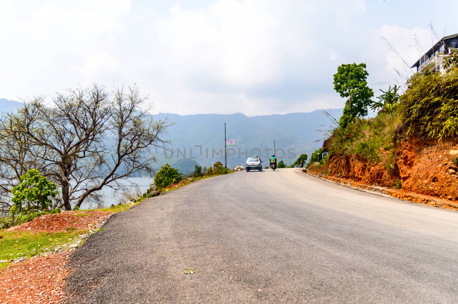 Photograph of empty road with hill in surrounding near Pokhara Lake at Kathmandu Nepal. Snap in portrait, landscape, wide screen style. Vintage film look. Vacation Freedom, Simplicity Concept.
