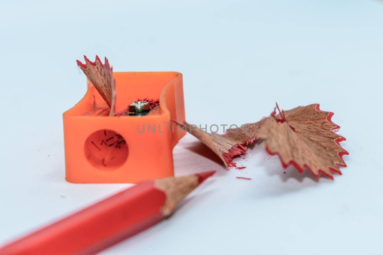 Color pencil with sharpener shavings on white background by sudiptabhowmick
