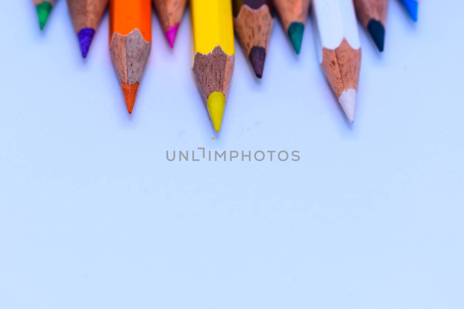 Selective Focus. Colored pencil set loosely arranged - on white background.