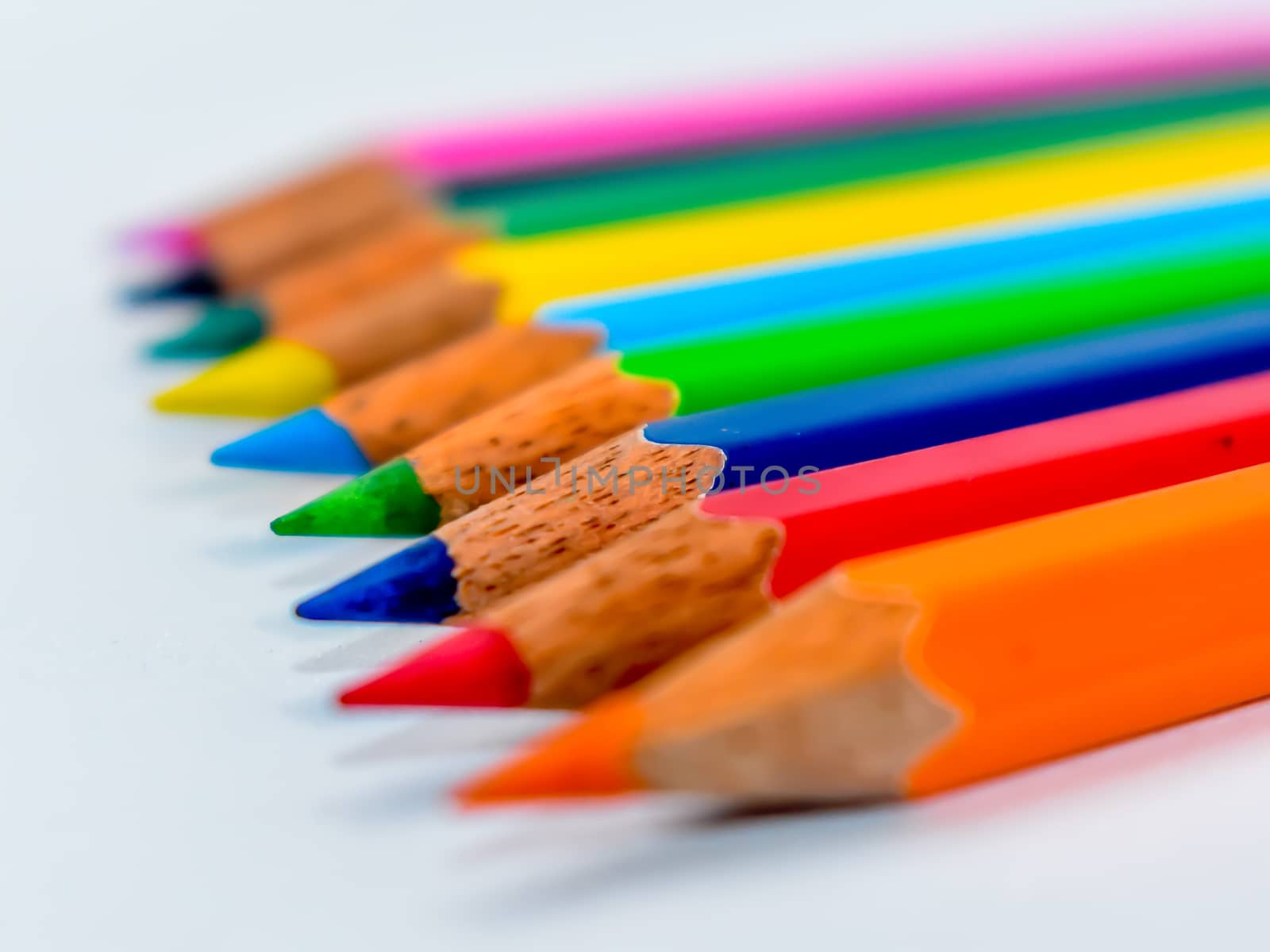 Pencils lined up in shallow focus. Color pencils isolated on white background for drawing with copy space.