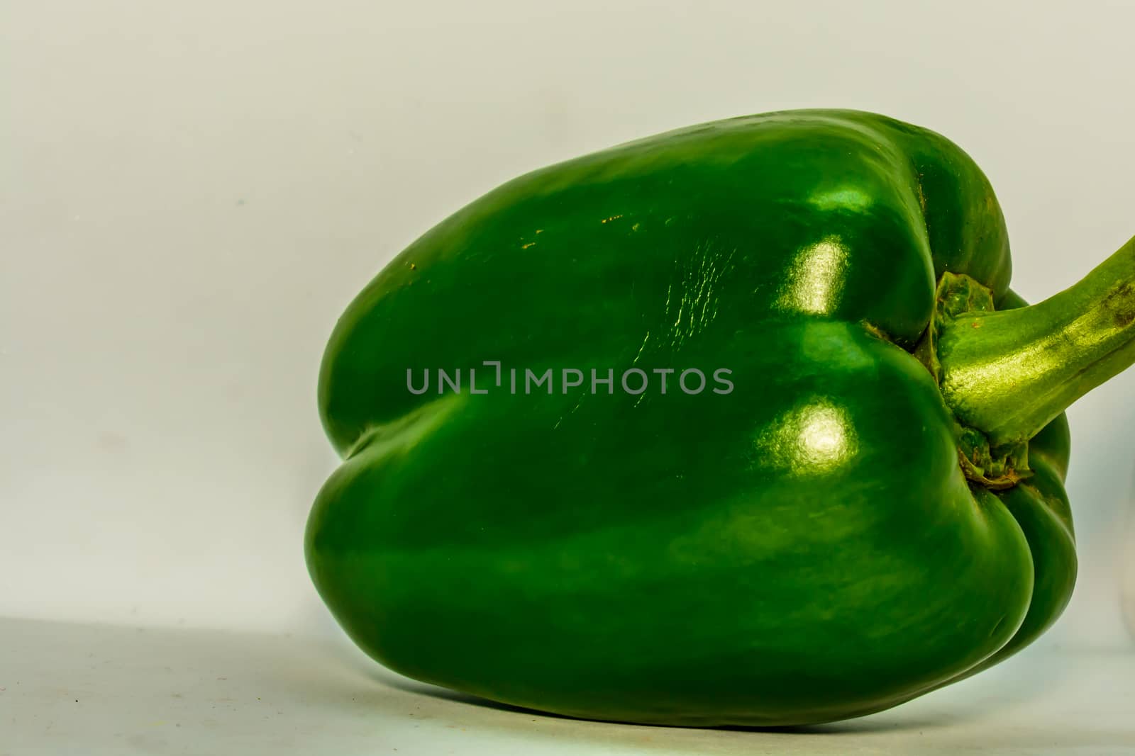 fresh green bell pepper (capsicum) on a white background by sudiptabhowmick