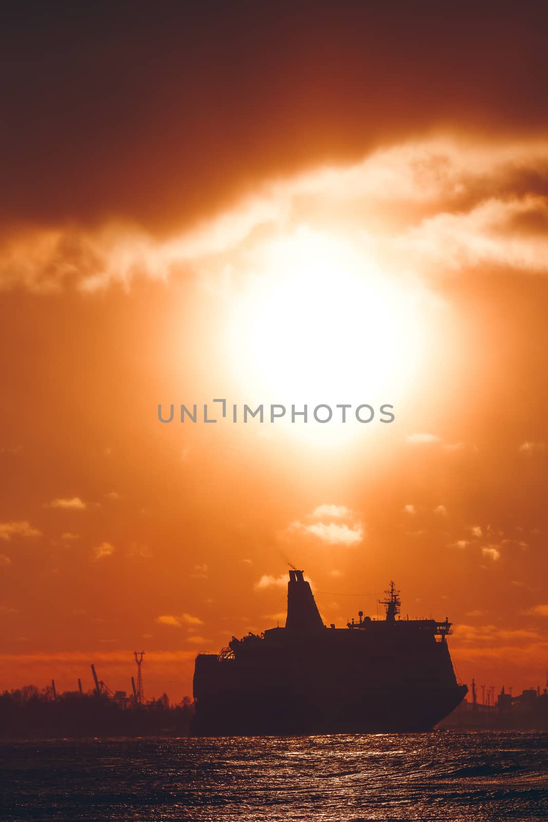 Hot orange winter sunrise against the cargo port