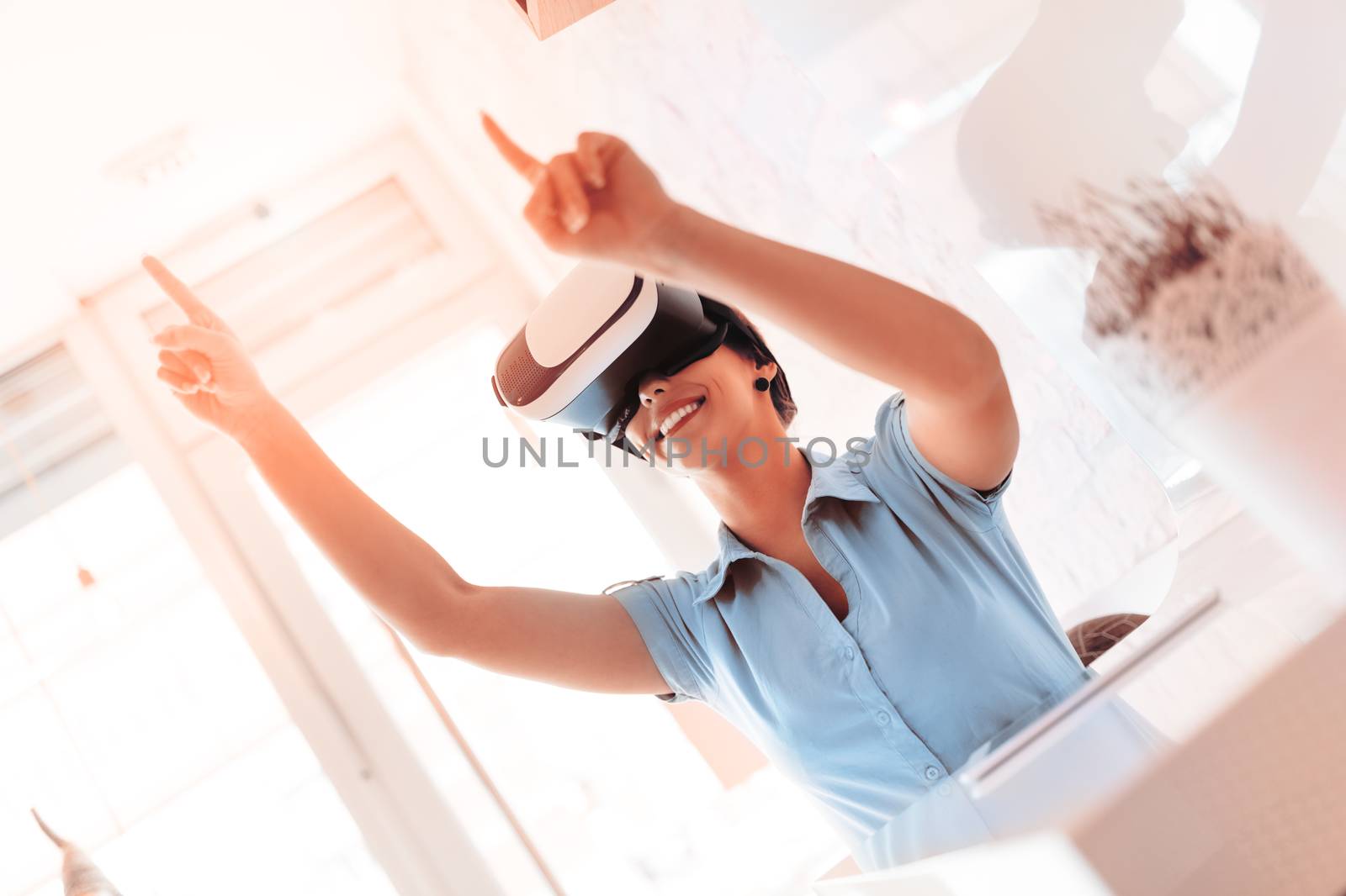 Smiling businesswoman using virtual reality glasses in a cafe.