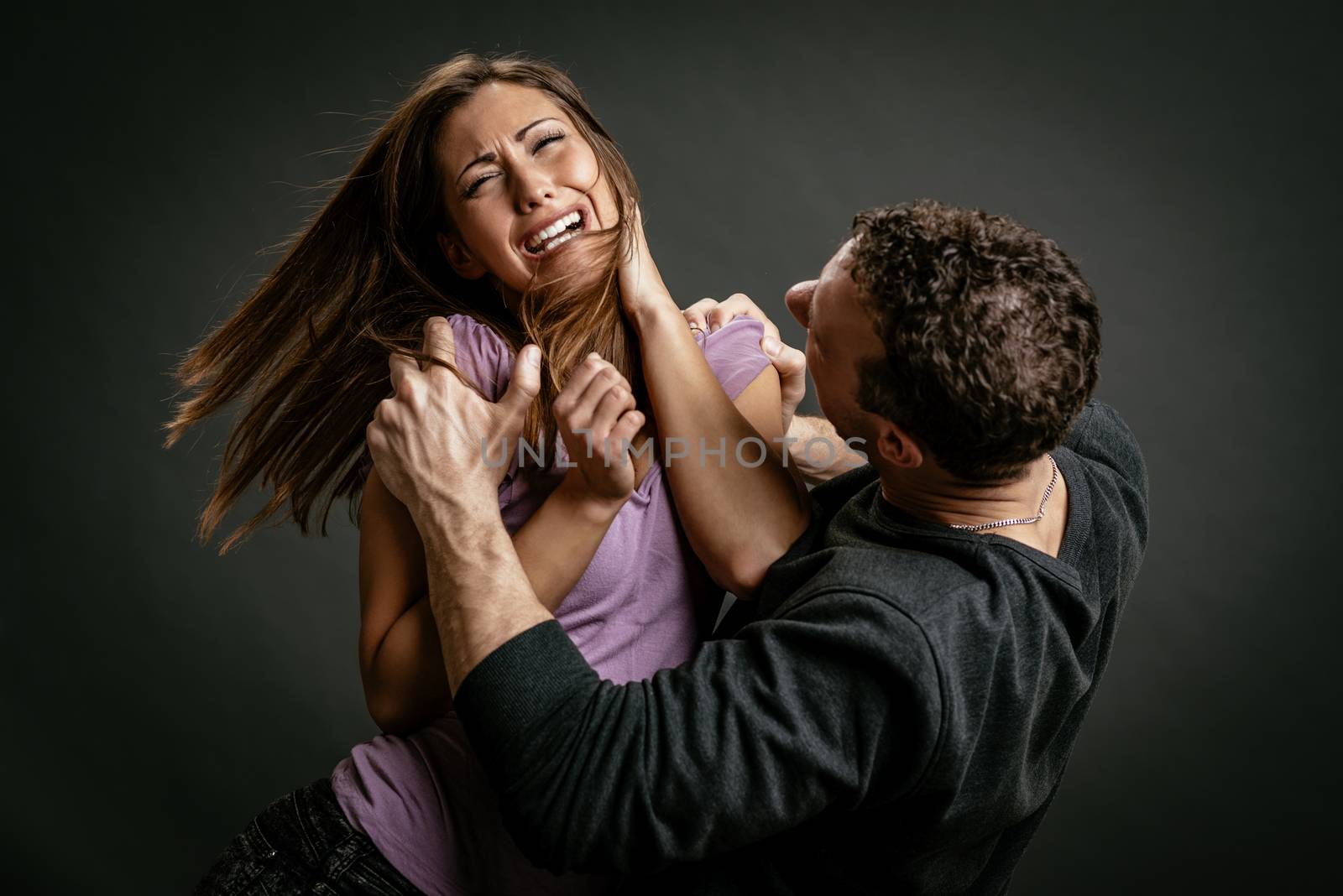 Angry aggressive husband trying to hit his wife.