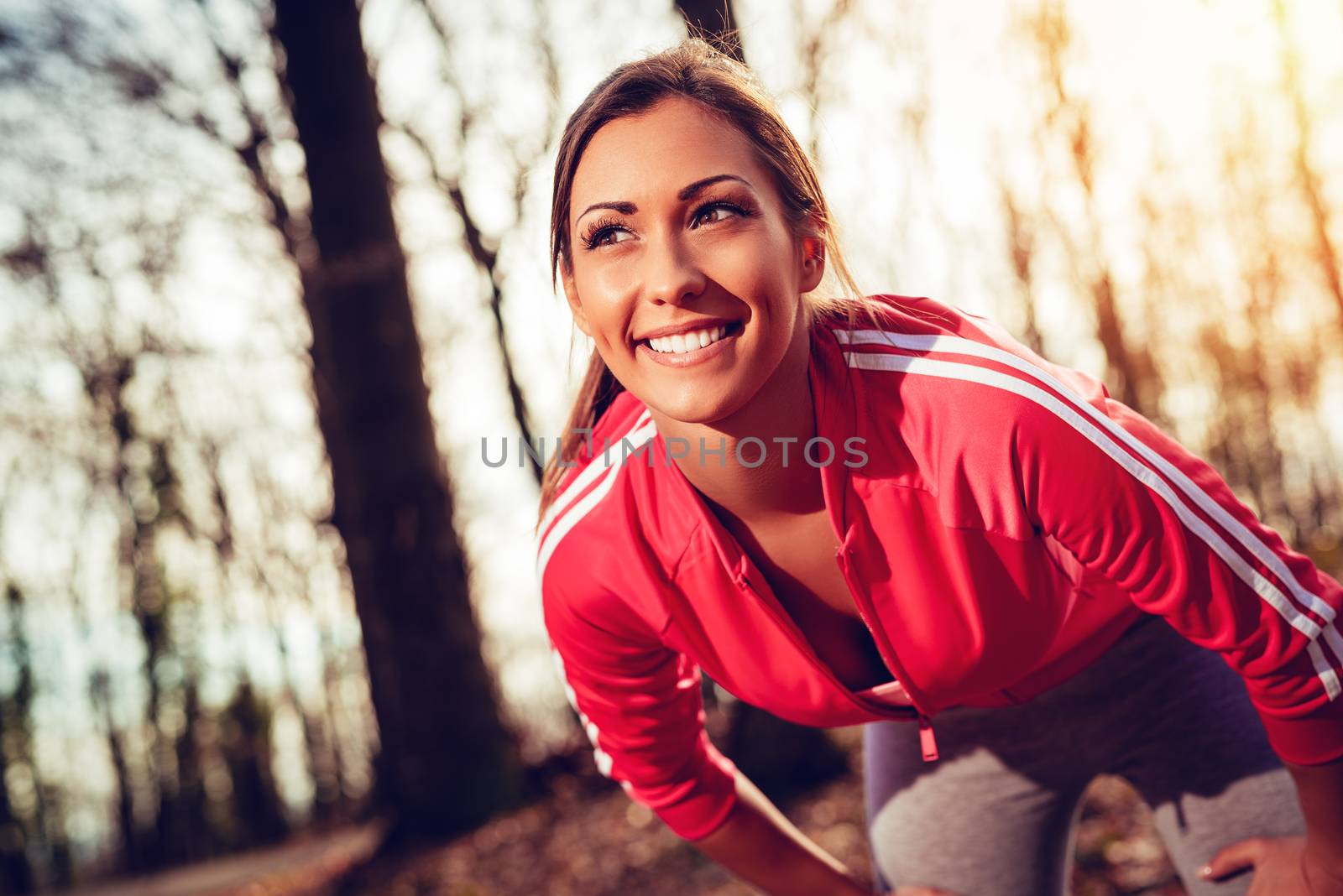 Portrait of a beautiful fitness running woman in the forest. 