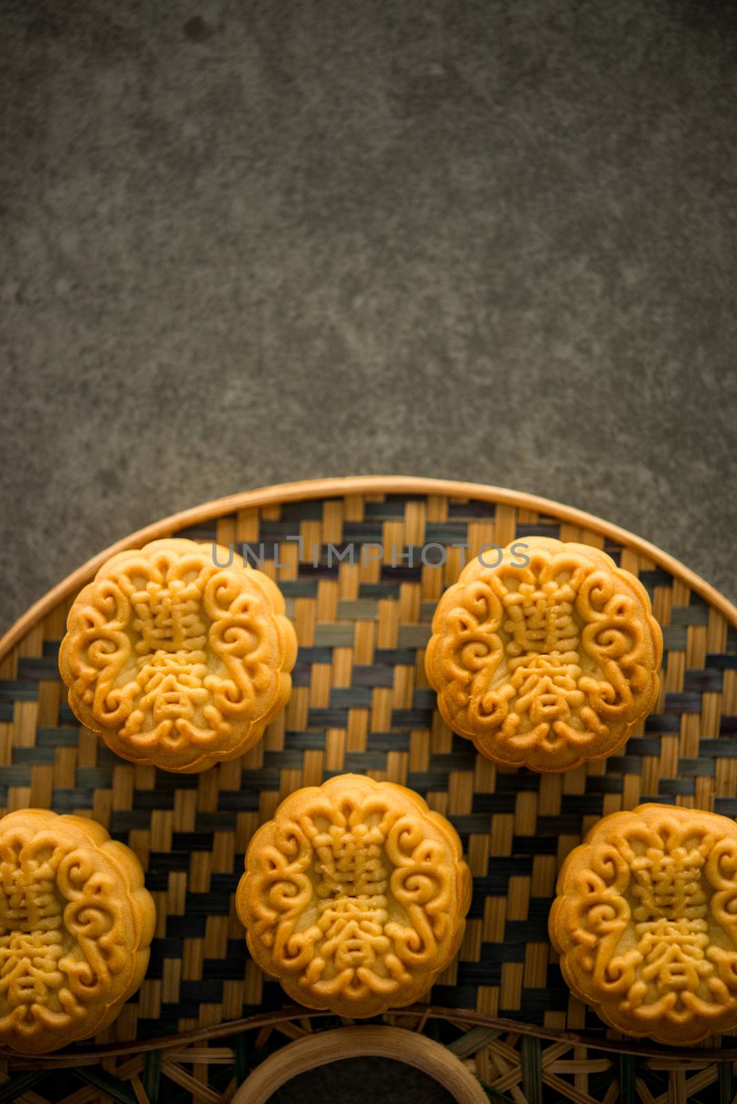 Traditional pastry mooncakes is offered to friends or family during Mid-Autumn Festival. Flatlay on table, top down view dark light with copy space. The Chinese character represent "lotus paste".