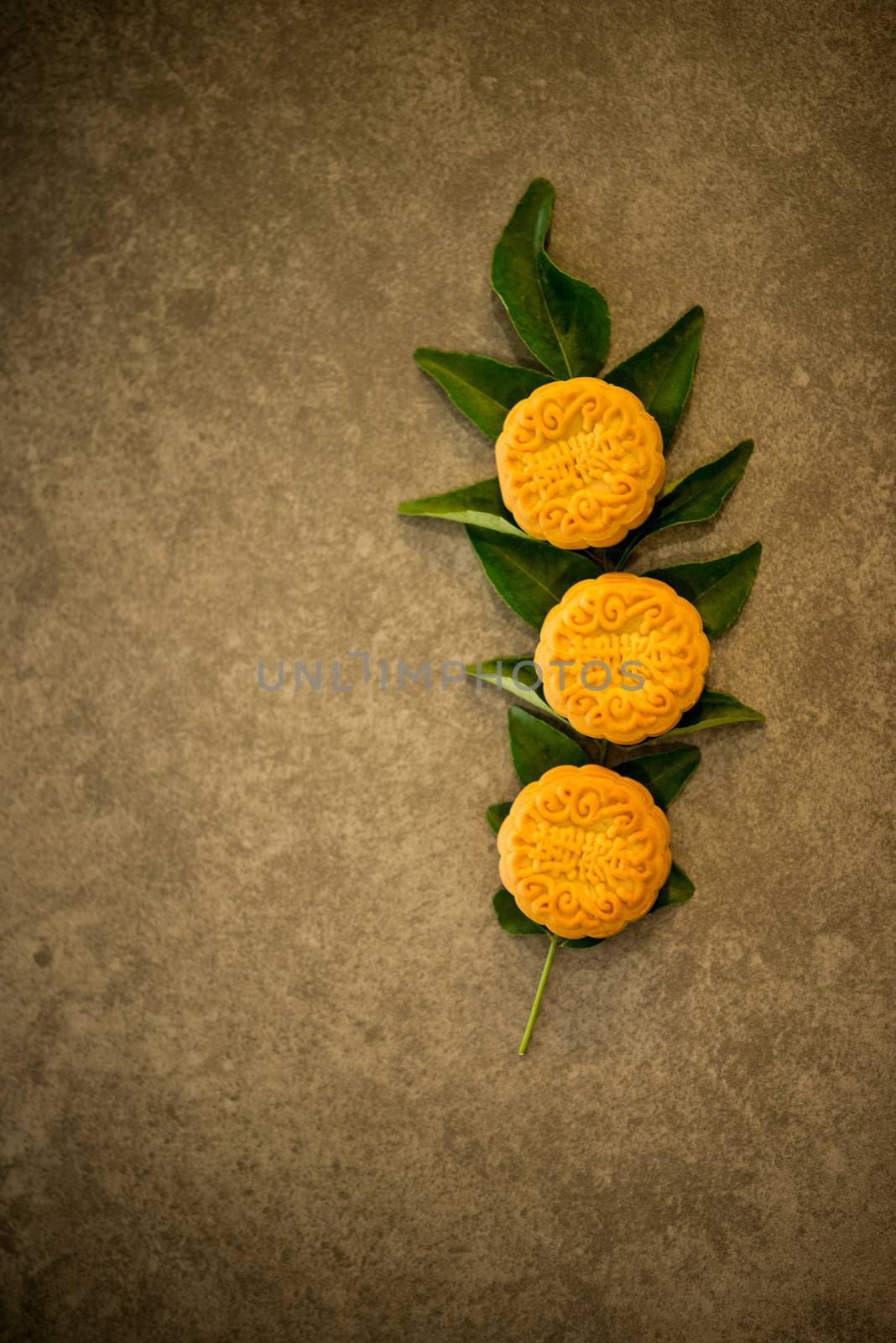 Mooncakes is traditional pastry eaten during the Mid-Autumn Festival. Flatlay on table top low light with copy space. The Chinese character represent "lotus paste".