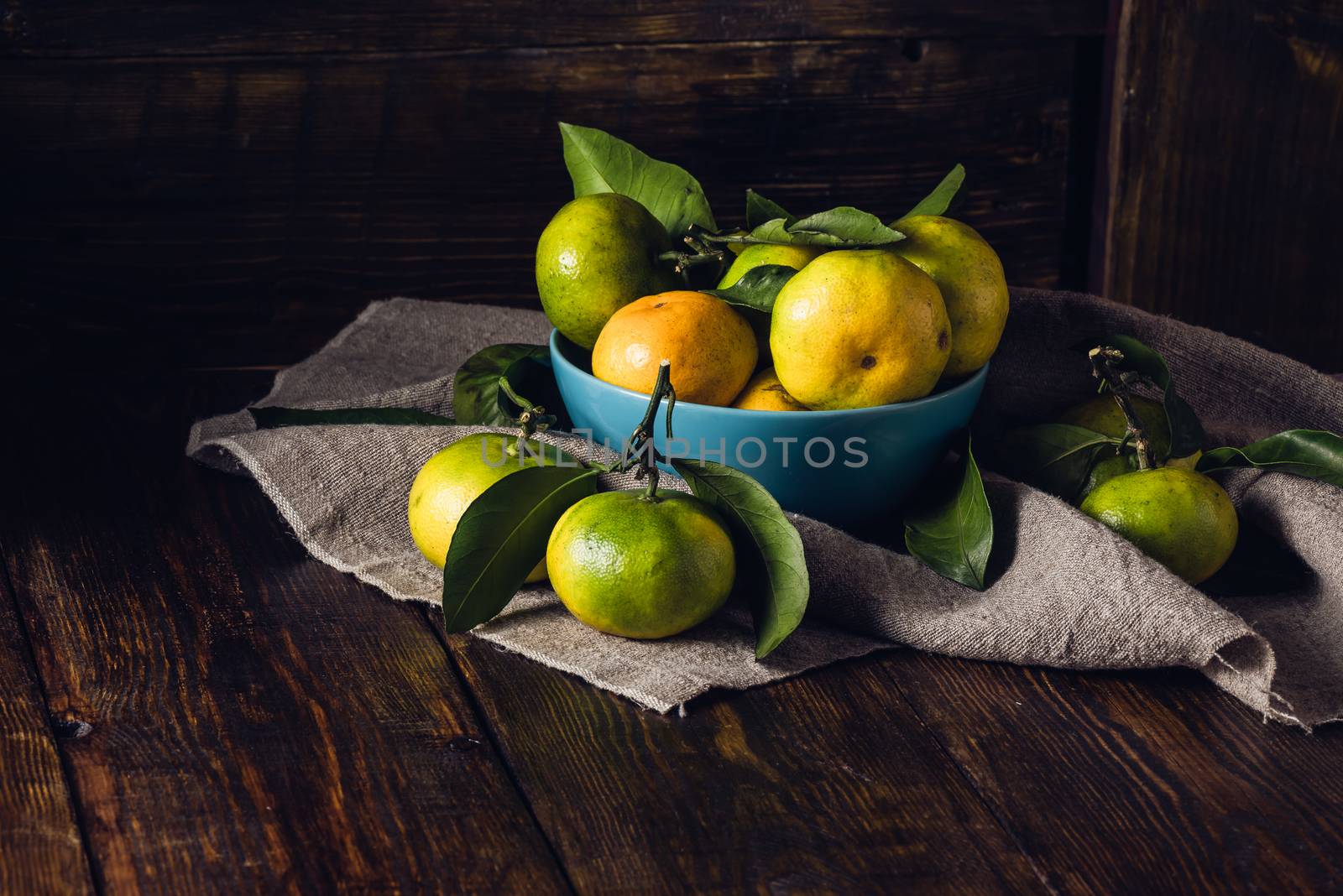 Yellow-green Tangerines with Leaves in Blue Bowl