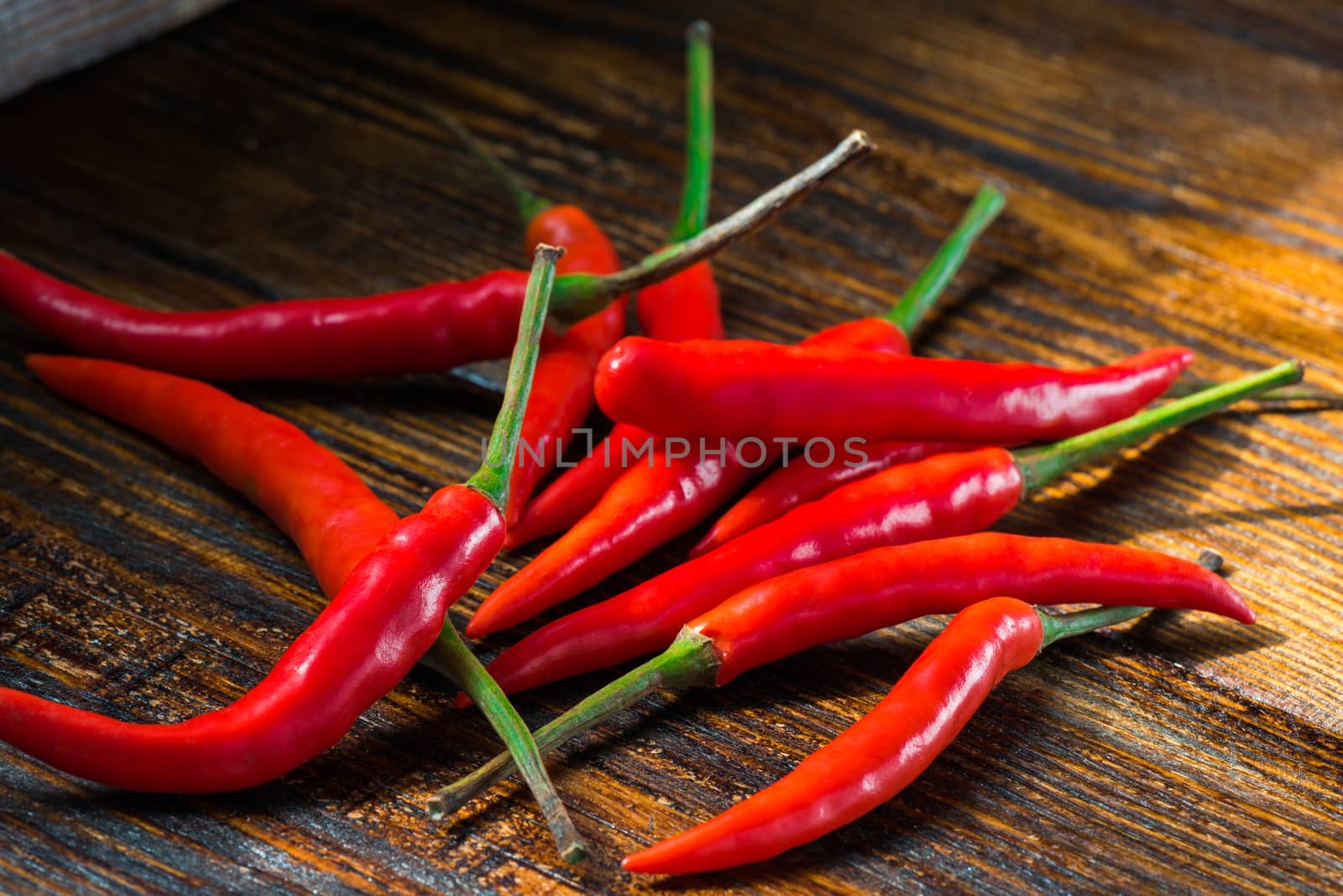 Pile of Mexican mini chili peppers on wooden background. Burning seasoning