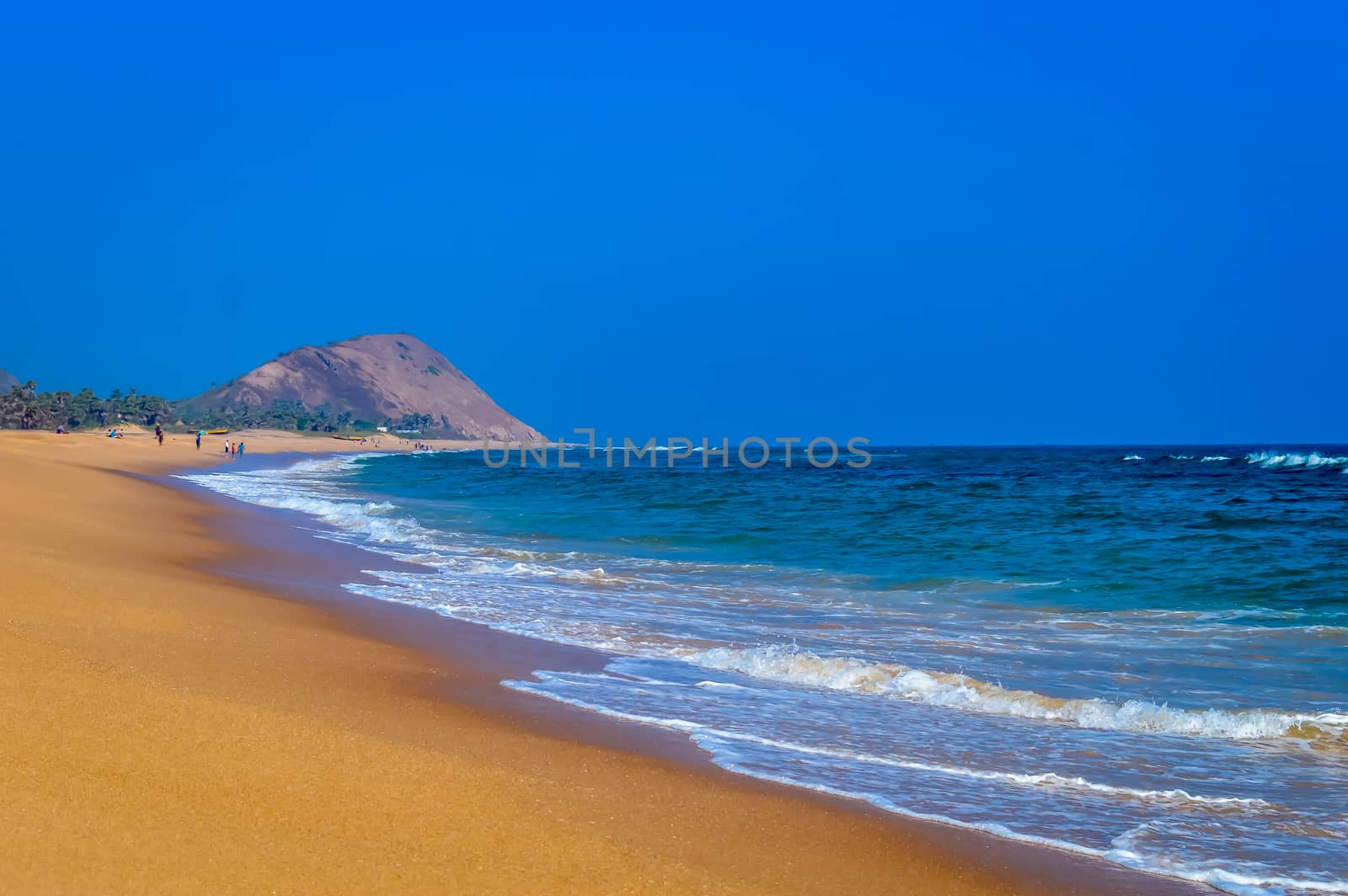 Wild Empty Tropical beach, vibrant yellow sand, bright blue sky, crystal clear waters with water crashing on the shore at daytime on a sunny day in in as landscape style may be used as a background, wallpaper, screen saver Travel vacation concept. The image is exciting, bright, sensational, tranquil, calm, stunning