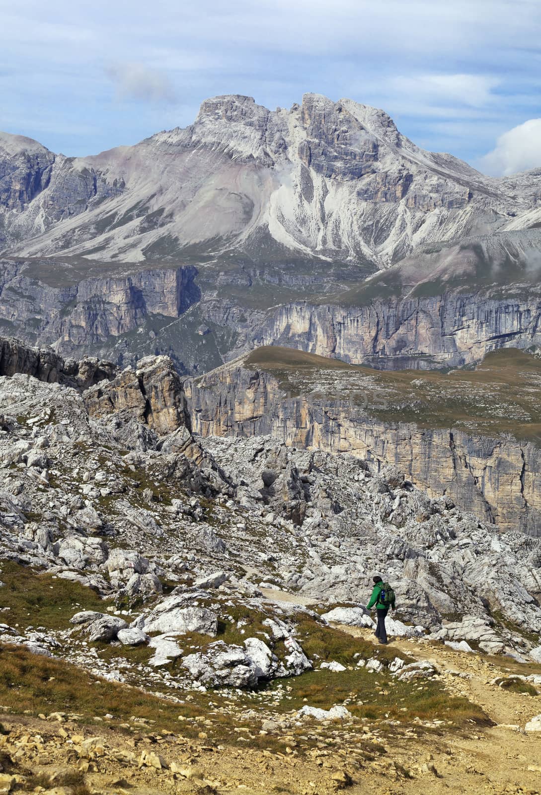 Hiker walking on a path in Dolomites, Italy