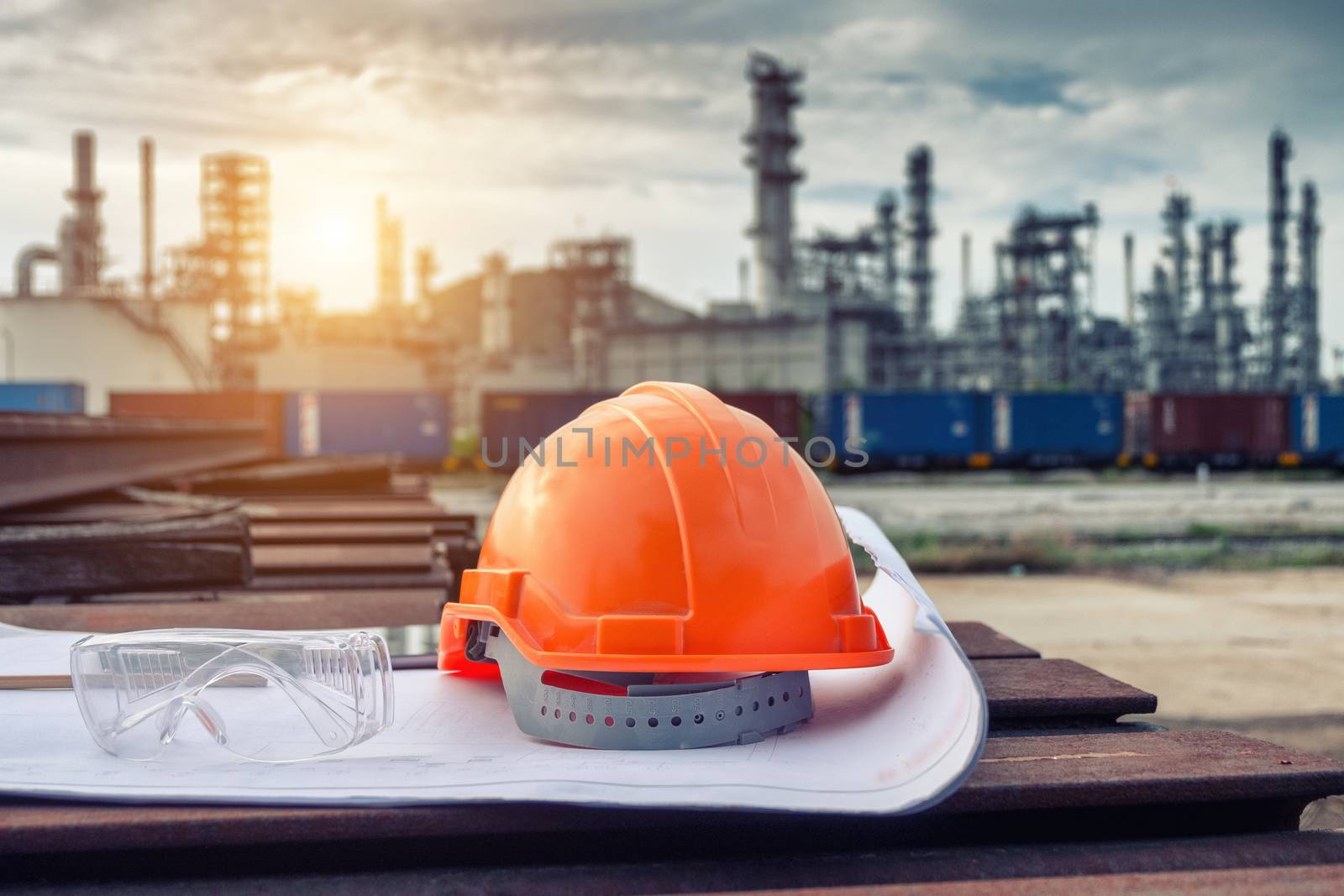 Helmet construction and safety glasses on the blueprint with industrial background.